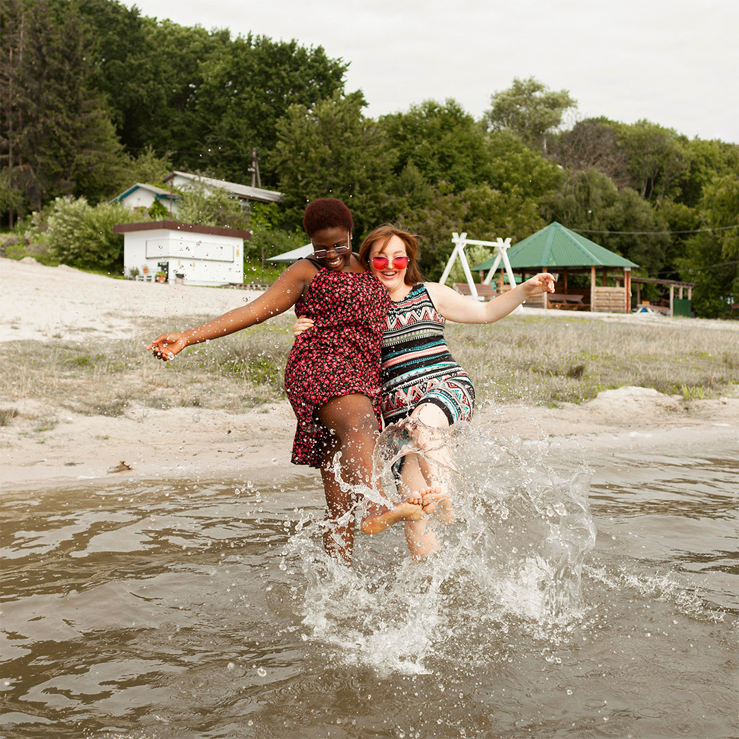 happy-women-playing-with-water-beach